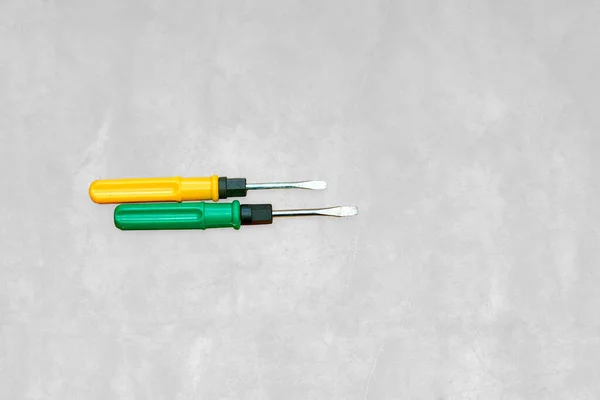 Yellow and green screwdrivers on gray marble background — Stock Photo, Image