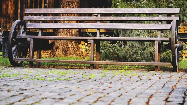 舗装石の上にカートホイールと木製のヴィンテージベンチ — ストック写真