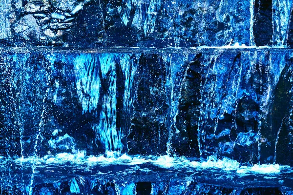 L'eau pure bleue minérale coule sur les pierres de montagne — Photo