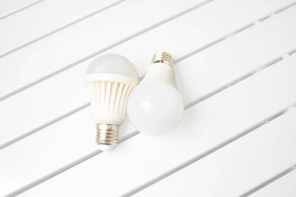 Two LED bulbs on a striped table — Stock Photo, Image