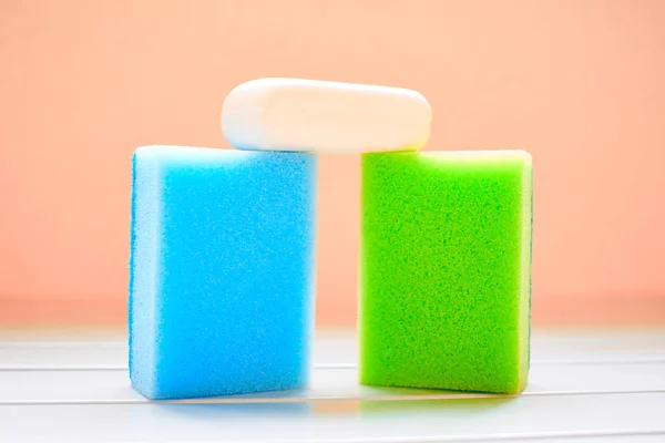 Δύο χρωματιστά σφουγγάρια και λευκό σαπούνι για καθαρισμό — Φωτογραφία Αρχείου