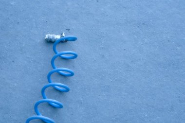 Arabanın tekerleklerini asfalt havayla şişirmek için sarmalanmış hortum