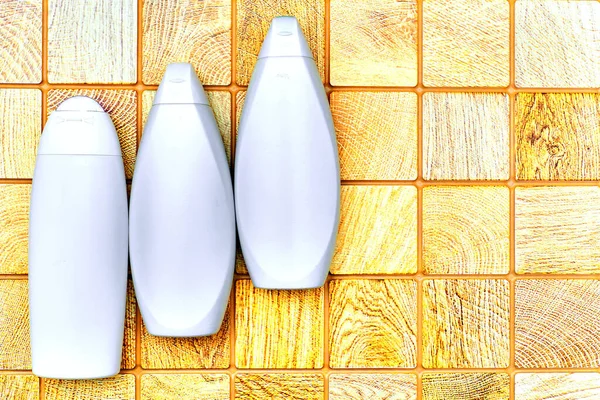 Plastic bottles for detergents against the background of orange wood squares — Stock Fotó