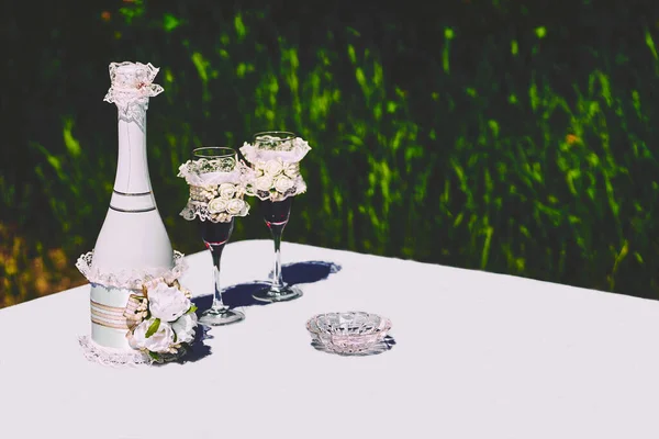 Akcesoria ślubne i szampan z okularami do małżeństwa w letnim parku — Zdjęcie stockowe