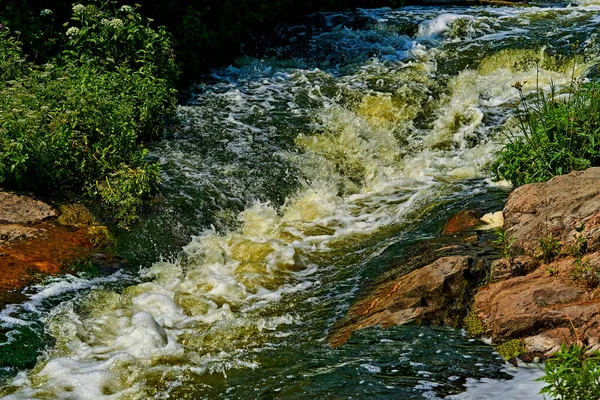 Stormy fast foaming stream of a strong mountain river on a warm day — Stockfoto