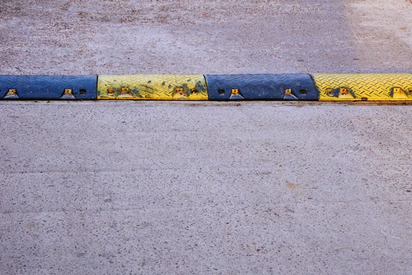 Black and yellow speed bump on chipped asphalt — Φωτογραφία Αρχείου