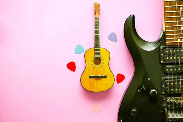 a stringed instrument, with a fretted fingerboard, and six or twelve strings, played by plucking or strumming with the fingers or a plectrum. electric guitar acoustic guitar picks on a pink background