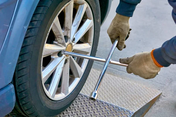 Replacing a car wheel at a tire station. a rubber covering, typically inflated or surrounding an inflated inner tube, placed around a wheel to form a flexible contact with the road