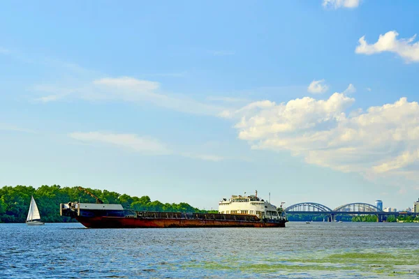 a vessel larger than a boat for transporting people or goods by sea. Motor ship barge dry cargo ship floating on the summer river.