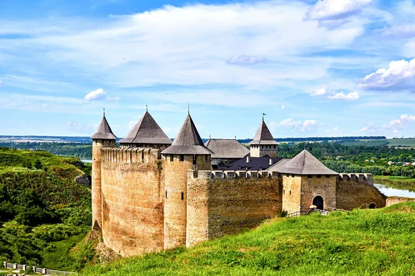 a military stronghold, especially a strongly fortified town fit for a large garrison. Old medieval fortress museum on green hills by the river