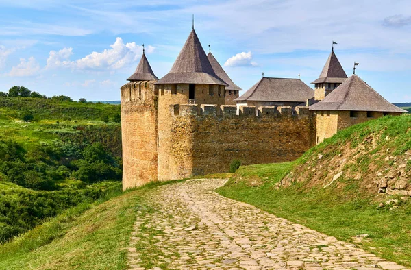 a military stronghold, especially a strongly fortified town fit for a large garrison. Old medieval fortress museum on green hills by the river