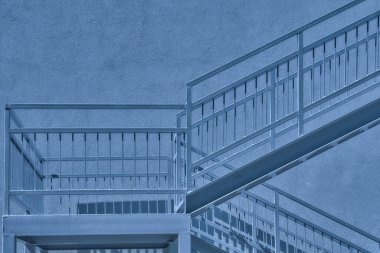 Bir merdiven seti ve etrafındaki duvarlar ya da yapılar. Mavi ay ışığında gri metalik merdiven iniş ve duvar . 