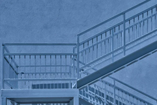 階段とその周囲の壁や構造物です 青い月明かりの下で灰色の金属製の階段着陸と壁 — ストック写真