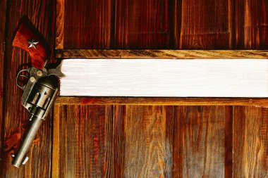 Döner odalı bir tabanca yeniden doldurulmadan birkaç el ateş edilmesine olanak sağlıyor. Kovboy tabancası Colt tabancası ahşap duvarda asılı. Mesaj için yeri var.