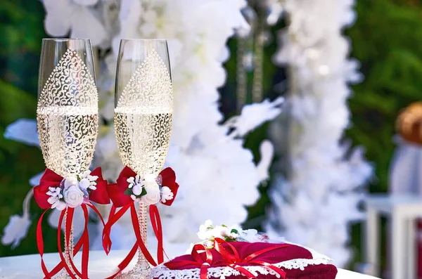一种结婚仪式 特别被认为包括相关的庆祝活动 两只婚庆水晶玻璃杯 上有红丝带和婚纱装饰 — 图库照片