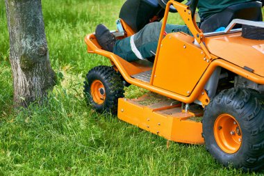 a machine for cutting the grass on a lawn. Professional grass cutting on lawns with a mini tractor lawn mower. . 