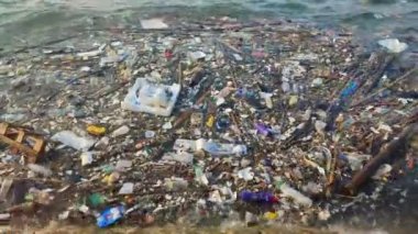 Çöpler kıyıda yüzüyor. Çevre kirliliği. Çöp, plastik şişeler, torbalar, suda yüzen çöpler. Deniz suyu kirliliği kavramı.
