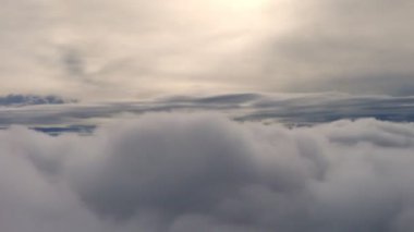 Arka plan için uçağın penceresinden bulutlar görünüyor. Bulutların üzerinde uçuyor, havada uçuyor.. 