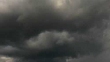 4K zaman kaybı, gri ve beyaz yuvarlanan kabarık bulutlar gökyüzünde yüzüyor. Fırtına Bulutları Yağmuru Konsepti. 