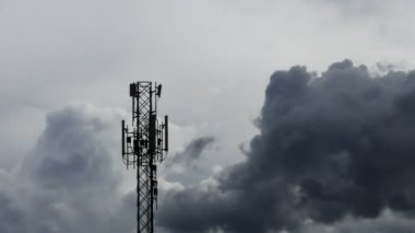 4K zaman atlaması, Telekomünikasyon kuleleri, hareket bulutları gökyüzü arkaplanı. Gökyüzü bulutları hareket halindeki kule sinyalinin zaman aşımına uğramış görüntüsü