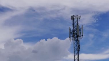 4K zaman atlaması, Telekomünikasyon kuleleri, hareket bulutları gökyüzü arkaplanı. Gökyüzü bulutları hareket halindeki kule sinyalinin zaman aşımına uğramış görüntüsü