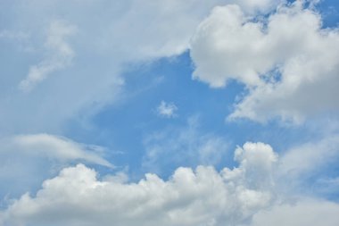 Beyaz bulutlar arka plan için mavi gökyüzüne karşı. Kabarık beyaz bulutlar gündüz gökyüzüne karşı. Cumulus pamuk yumağı gibi yumuşak bir buluttur.