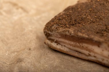 Beyaz yağlı kağıtta biberli ev yapımı pastırma, yakın plan, seçici odaklı.