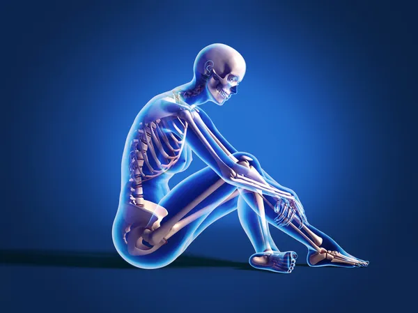 Woman sitting on floor, with bone skeleton. — Stock Photo, Image