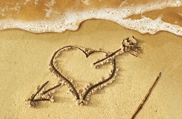 Cuore con freccia, come segno d'amore, disegnato sulla spiaggia, con s — Foto Stock