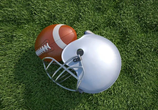 Helmu amerického fotbalu a míč, na trávě. zblízka. — Stock fotografie