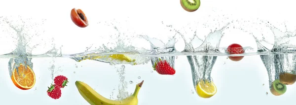 Various fruits splashing in water. Side panoramic view on white background.