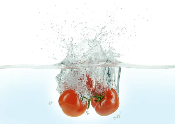 三只西红柿在水里泼洒 — 图库照片