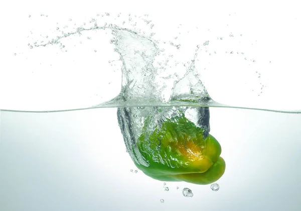 緑色の唐辛子が水に飛び散った 白地の側面図 ロイヤリティフリーのストック画像
