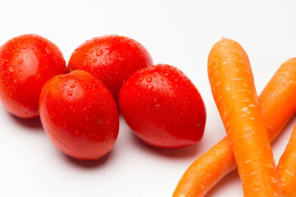 白い背景に赤とオレンジのトマトとニンジン — ストック写真