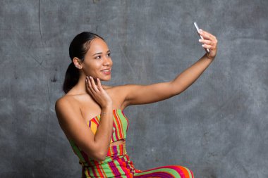 Fotoğrafta güzel görünmek için selfie çeken genç bir kız.