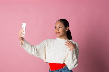 Fotoğrafta güzel görünmek için selfie çeken genç bir kız.