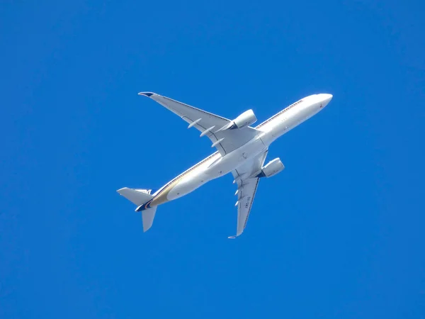 Commercial passenger aircraft flying over blue sky — Stock Photo, Image