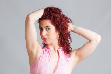 Genç, güzel ve seksi bir kadının beyaz arka planında poz veriyor.