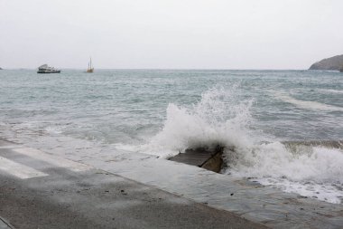 Dalgalar, kötü deniz, dalgalar limana ve kayalara çarpıyor..