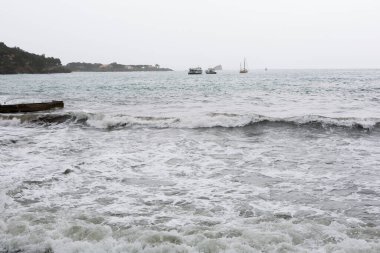 Dalgalar, kötü deniz, dalgalar limana ve kayalara çarpıyor..