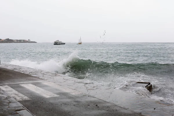 Dalgalar, kötü deniz, dalgalar limana ve kayalara çarpıyor..