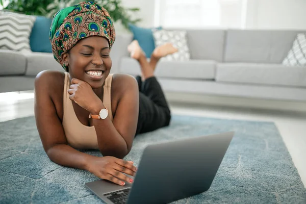 Smiling Young African Woman Sitting Her Legs Crossed Her Rug lizenzfreie Stockbilder