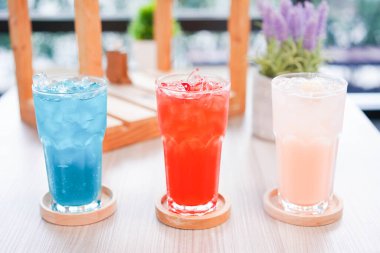 Buzda yaz için taze soğuk içecek. Sıcak bir gün ve parti için uzun bardakta, ahşap tabakla renkli bir yaz içkisi..