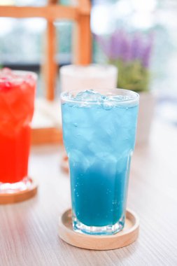 Buzda yaz için taze soğuk içecek. Sıcak bir gün ve parti için uzun bardakta, ahşap tabakla renkli bir yaz içkisi..