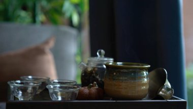 Geleneksel çay seti tepsisi, modern şeffaf tencere ve rahat Çin odasında temiz küçük bardak. Kurumuş yapraklı, doğal ve sağlıklı bir içecek güzel bir koku verir ve rahatlar..