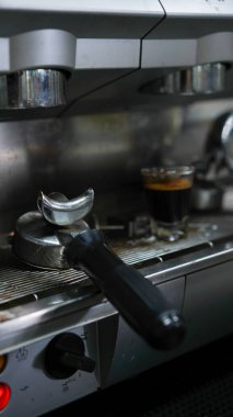 Elinde kahve damlatan moka demliğinden kahve var. Barista çaydanlık ve geleneksel damlatıcıyla kahve damlatıyor. Aroma kahve dükkanında el yapımı sade kahve.