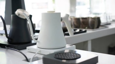 Elinde kahve damlatan moka demliğinden kahve var. Barista çaydanlık ve geleneksel damlatıcıyla kahve damlatıyor. Aroma kahve dükkanında el yapımı sade kahve.