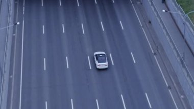 Amerikan köprüsünün altından geçen beyaz arabanın insansız hava aracı görüntüsü.