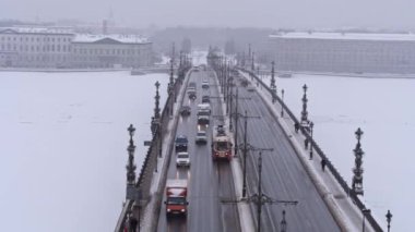 Şehir trafiğinin en üst görüntüsü. Tramvay ve arabalar kışın köprüden geçer..