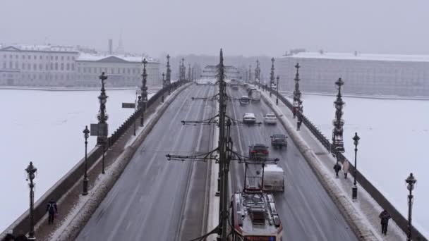 Вид на снежный мост и автомобильное движение с беспилотника. Трамвай идёт по мосту.. — стоковое видео
